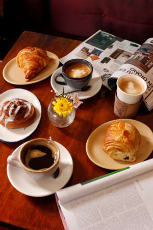 Variety of coffee cups and bread on old wooden tableのeditorial素材