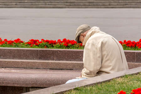 The old man sits resting in a park