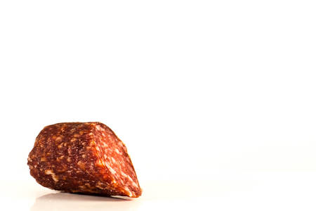 A piece of smoked sausage on a white backgroundの写真素材