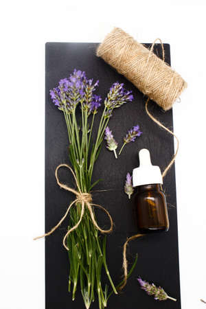 Spring of lavender on a wooden background with a glass bottle to make oilの写真素材