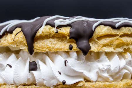 A crown-shaped cake containing layers of puff creme and chocolate, with icing sugarの写真素材