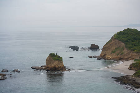 Seascape of ecuadorian shore with sand and rocksの写真素材