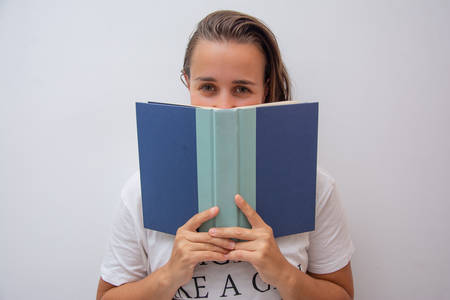 Woman looking above a book and smiling