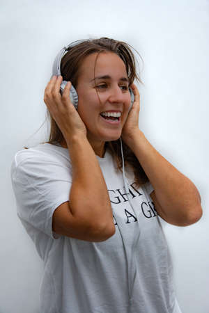 Happy woman singing while listening to music with headphones