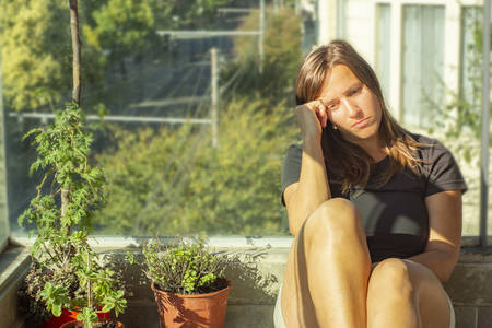 Woman feeling depressed during quarantine at balconyの写真素材