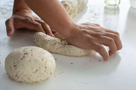 Man kneading a large dough for homemade bread in quarantineの写真素材