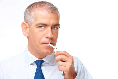 Mature man smoking cigarette with lighter in hand, isolated over white backgroundの写真素材