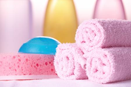Bath care objects. Olive, shampoo and gel in background towels, sponge and soap.の写真素材