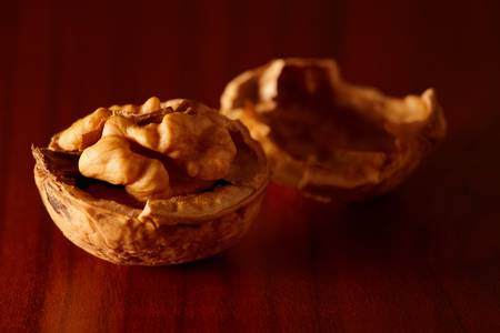 Walnut and nutshell on wooden table. Nice side lighting.の写真素材