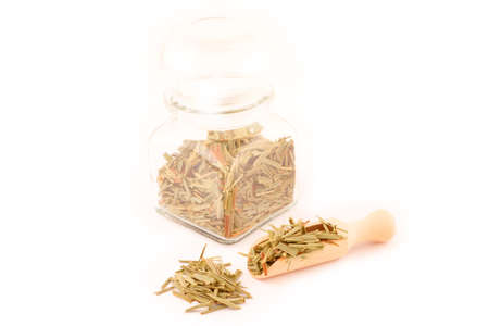 Dried lemongrass on wooden spoon and in the glass jar isolated on whiteの写真素材
