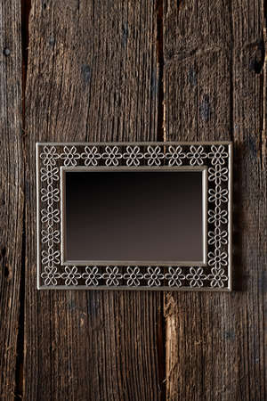 Metal frame with empty space for your image over old wooden background wall