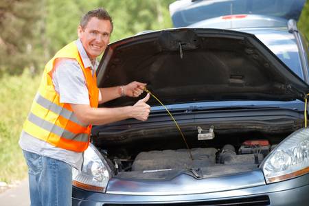 Man checking level of oil on a car engine dipstick, and showing ok signの写真素材