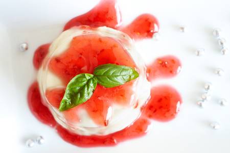 Panna cotta Italian dessert made by simmering together cream, milk and sugar, mixing this with gelatin, and letting it cool until set  Here with raspberry sweet sauce の写真素材