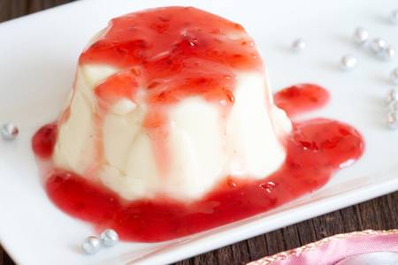 Panna cotta Italian dessert made by simmering together cream, milk and sugar, mixing this with gelatin, and letting it cool until set  Here with raspberry sweet sauce の写真素材
