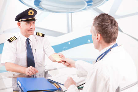 Airplane pilot during medical exam with doctor giving him a medical certificate