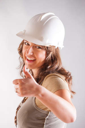 Smiling woman architect designer wearimh hardhat, thumbs upの写真素材