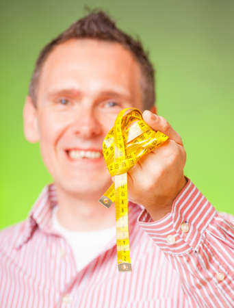 Man with tape measure, tailor, weight loss conceptの写真素材