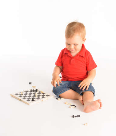 little boy playing chess isolated over white backgroundの写真素材