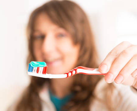 Woman holding toothbrush, focus on brushの写真素材