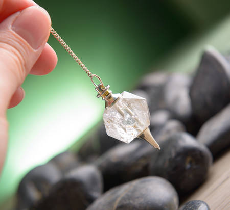 Hand with pendulum, tool for dowsing.の写真素材