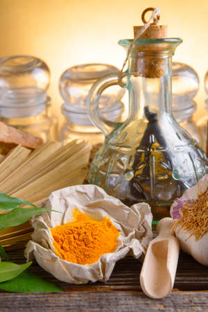 Tumeric powder spice on wooden board with other herbsの写真素材