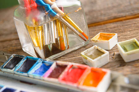 Professional watercolor aquarell paints in box with brushes in jar with waterの写真素材