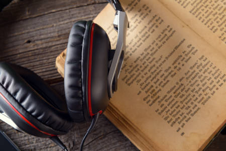 Headphones on the old book. Concept of listening to audiobooks.の写真素材