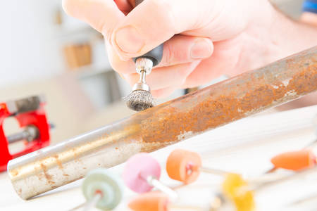 Using a high speed rotary multi tool to clean rusty pipe