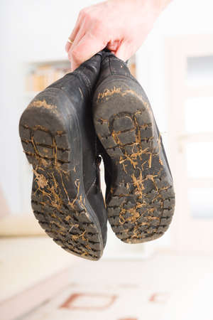 Hand holding worn dirty woman's shoesの写真素材