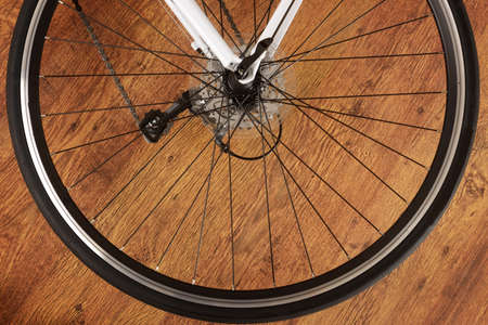 Rear bicycle wheel on the wooden floorの写真素材