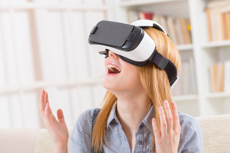 Happy woman using virtual reality headset at home
