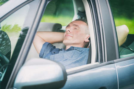 Man sleeping in the car before next part of the jurneyの写真素材