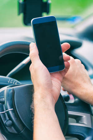 Man using smart phone while drivingの写真素材