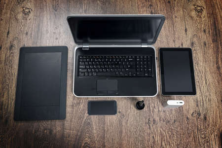 Top view of office desk with laptop computer, mobile phone, graphic tablet with pen and power bankの写真素材