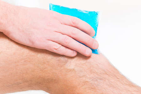 Man using cold gel compress on knee to reduce pain
