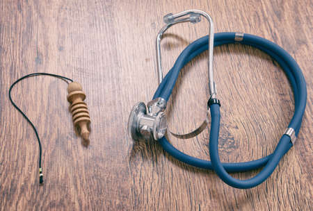 Pendulum and stethoscope on a wooden table as a concept of alternative medicineの写真素材