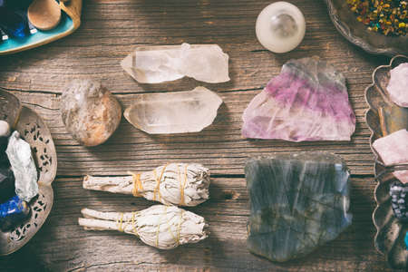 Natural gemstones, white sage and incense on wooden boardの写真素材