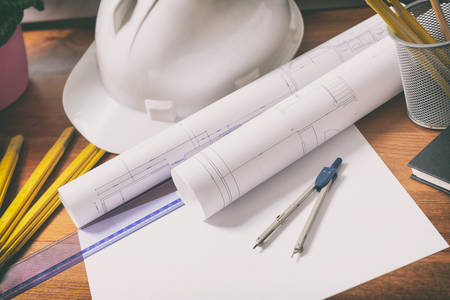 Construction plans with helmet and drawing tools on blueprints and measureの写真素材