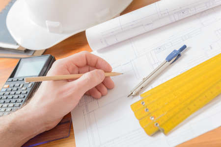 Architect at work. Construction plans, blueprint, measure, ruler and drawing tools