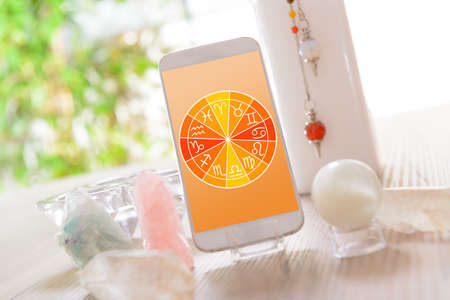 Zodiac signs and smart phone with crystal balls. Concept of modern astrology.