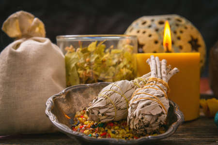 White sage, colorful incense candle and Linden flowers on wooden boardの写真素材
