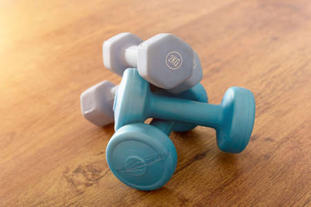 Blue dumb-bells  over wooden gym's floor の写真素材