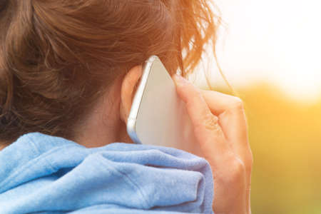 Woman talking on cell phone, back viewの写真素材