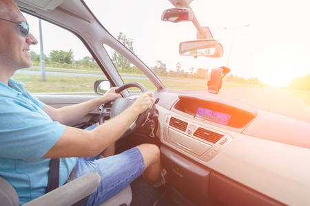 Driving a car - passenger seat view. Hands on steering wheel