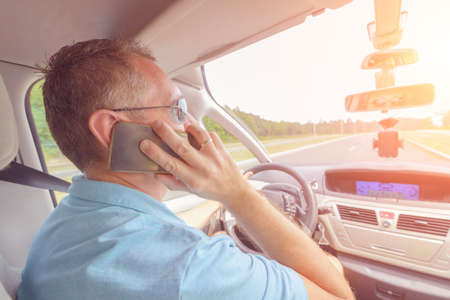 Man using phone while driving the car. Risky driving behaviors concept