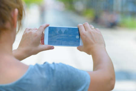 Woman taking photo on a street with smartphone