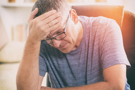 Tired man sitting at home office の写真素材