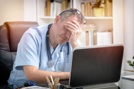 Overworked doctor sitting in his office の写真素材