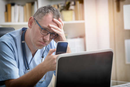 Overworked doctor sitting in his office の写真素材