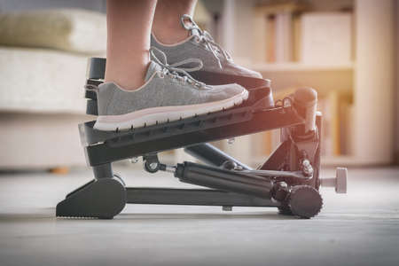 Woman doing exercises on stepper at home